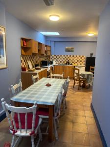 a dining room with a table and chairs and a kitchen at Coastguard Lodge Hostel at Tigh TP in Dingle +12 photos