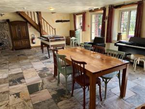 a dining room with a table and a piano at Fermette Erpigny in Fasol