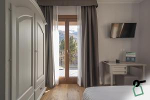 Postel nebo postele na pokoji v ubytování HOTIDAY Bormio Centro