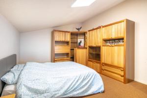 a bedroom with a bed and wooden cabinets at Les Crocus - Magnifique Vue Montagne in Comboursière