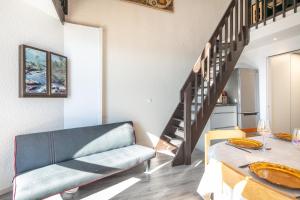 a living room with a couch and a table at Les Crocus - Magnifique Vue Montagne in Comboursière
