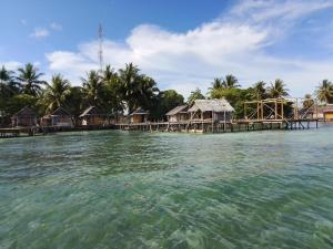 a group of houses on a small island in the water at Kasumasa Homestay in Fambemuk