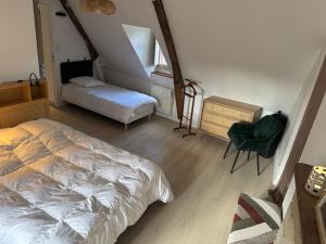 L'écrin au Coeur du Village في روشفور-أون-تير: غرفة نوم بها سرير وكرسي