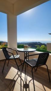 2 Stühle und ein Tisch auf dem Balkon in der Unterkunft צימר החורש in Dāliyat el Karmil