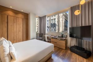 a hotel room with a bed and a flat screen tv at Hyatt Centric Gran Via Madrid in Madrid