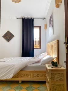 ein Schlafzimmer mit einem Bett mit einem blauen Vorhang in der Unterkunft Palais Taroudant in Taroudant