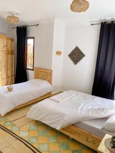 2 Betten in einem Zimmer mit schwarzen Vorhängen in der Unterkunft Palais Taroudant in Taroudant + 6 Fotos