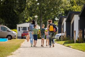 a group of people walking down a road at Camping de Vogel in Hengstdijk