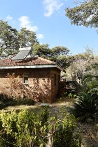 ein Backsteinhaus mit einem Solarpanel auf dem Dach in der Unterkunft Cozy Ensuite Borrowdale in Harare