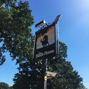 a sign for a black horse on a pole at The Black Horse at Ireland in Shefford