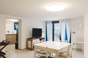 Villino Elvira في كوستوناتشي: غرفة معيشة مع طاولة بيضاء وتلفزيون