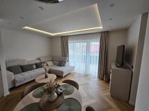 a living room with a couch and a table at Gold Residence Apartman in Hajdúszoboszló