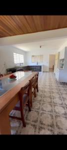 a large kitchen with a long table and chairs at Fazenda Torrão da Serra in Guarulhos