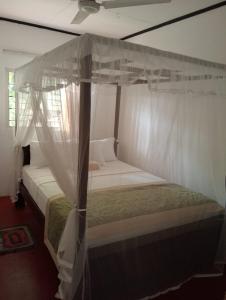una camera da letto con un letto a baldacchino di Omandi Villa a Weligama