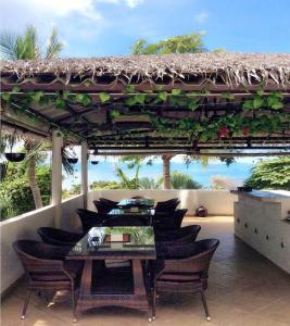 eine Terrasse mit Tisch und Stühlen und dem Meer in der Unterkunft Little Hill in Haad Rin