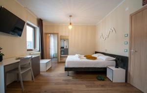 Hotel Casa Alpina في فولاريا: غرفة نوم بها سرير ومكتب وجهاز كمبيوتر +26 صورة