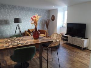 un soggiorno con tavolo, sedie e TV di LE TROPICOCO - hyper centre d'Auray - ad Auray