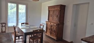 a dining room with a table and a large wooden cabinet at Maison de vacances au milieu des vignes in Cazaubon +9 photos