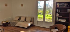 a living room with a couch and a window at Maison de vacances au milieu des vignes in Cazaubon