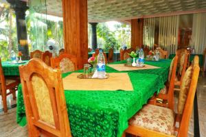 a long table with a green table cloth and chairs at Aditi Ayurveda Panchkarma Retreat in Vilinjam