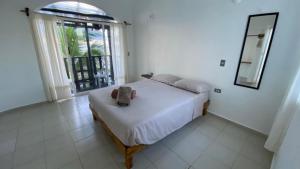 Un dormitorio con una cama y un espejo y una ventana. en Casa Kayab, en Puerto Morelos 24 fotos más