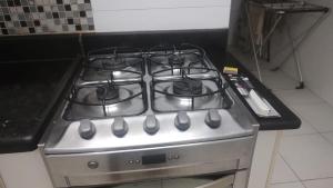 a stove with four burners on it in a kitchen at 2 Qts próx Vila Militar, Sulacap e Campo dos Afonsos in Rio de Janeiro