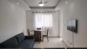 a living room with a couch and a dining room table at 2 Qts próx Vila Militar, Sulacap e Campo dos Afonsos in Rio de Janeiro