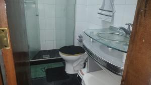 a bathroom with a sink and a toilet with a glass shower at 2 Qts próx Vila Militar, Sulacap e Campo dos Afonsos in Rio de Janeiro