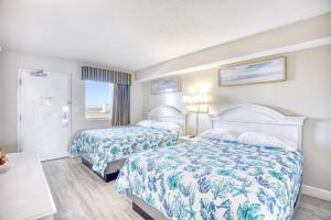 マートルビーチにあるCamelot by the Sea Resort Unit 1205 Direct Oceanfront Condo with Balconyのベッドが2つと窓があるホテルの部屋