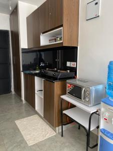 a small kitchen with a stove and a microwave at LiFran suites in Ongata Rongai 