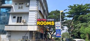a sign on the side of a building that reads metro orange rooms at Metro Residency in Perintalmanna