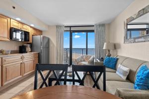 een keuken en woonkamer met een bank en een tafel bij Beach Cove Resort Unit 423 Oceanfront Condo with Balcony in Myrtle Beach