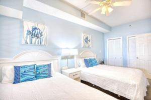 een slaapkamer met twee bedden en een plafondventilator bij Beach Cove Resort Unit 321 with Direct Oceanfront Balcony in Myrtle Beach +35 foto's
