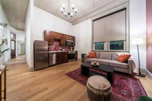 a living room with a couch and a refrigerator at Scarlet Suite in Sedalia