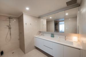 a bathroom with a sink and a shower and a mirror at Oceana - A Panoramic Beachfront Escape for Groups in Port Elliot +23 photos