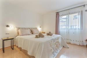 a white bedroom with a bed with two shoes on it at Casa Piña Colada in Corralejo