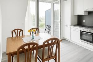 a kitchen and dining room with a wooden table and chairs at Deluxe Apartment Seeblick in Friedrichshafen