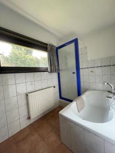 bagno bianco con vasca e finestra di Ferienhaus Lemmerwiese a Stryck Altre 8 foto