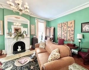 a living room with a couch and a fireplace at Wisteria Suite -The Belvedere Inn in Oswego