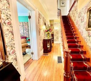 a staircase in a home with a red carpet at Wisteria Suite -The Belvedere Inn in Oswego +6 photos