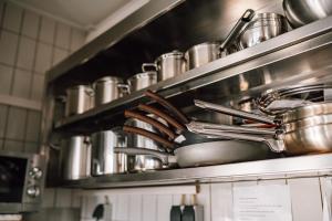 een bos potten en pannen op een plank in een keuken bij The Great View Sauna & more in Harscheid