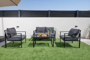 dwa krzesła i stolik z tacą z napojami w obiekcie רוי סוויטות בוטיק - 2 סוויטות עם מרפסת פרטית w mieście Jawne’el +14 zdjęć