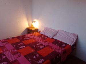 a bedroom with a bed with a quilt and a lamp at Herminia Sol in La Aguada