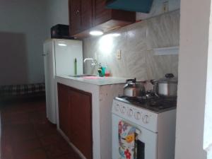 a kitchen with a stove and a white refrigerator at Herminia Sol in La Aguada