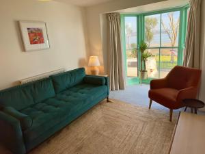 The Kittiwakes Perch في ذا مامبلز: غرفة معيشة مع أريكة خضراء وكرسي