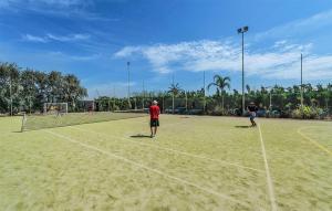 Nice Home In Tarquinia With Outdoor Swimming Pool في Porto Clementino: مجموعة من الناس يلعبون التنس على ملعب تنس