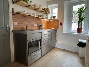 a kitchen with a sink and a counter top at The Kittiwakes Perch in The Mumbles +2 photos