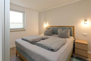 une chambre avec un lit avec des draps blancs et une fenêtre dans l'établissement Girlitz Nest, à Röbel