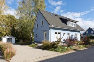 une maison blanche avec un toit gris dans une rue dans l'établissement Girlitz Nest, à Röbel