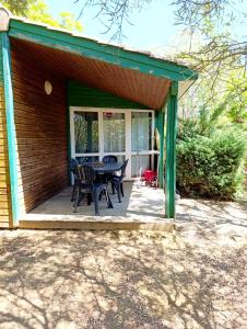 een patio met een tafel en stoelen op een huis bij Chalet 1 in Cazilhac